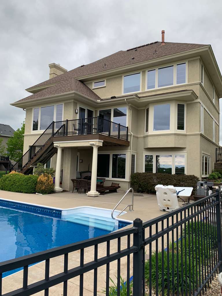 Large stucco home with pool exterior painting